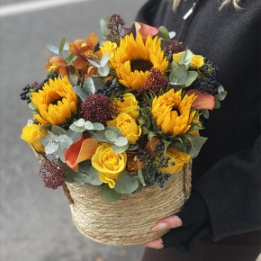 Композиция в сумке "Тональность" из подсолнухов, калл, ягод вибирнума, лимонных роз, скиммии и орхидеи в Истре