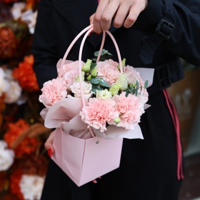 Стильная композиция в сумочке из диантусов, эвкалипта и эустом в Истре